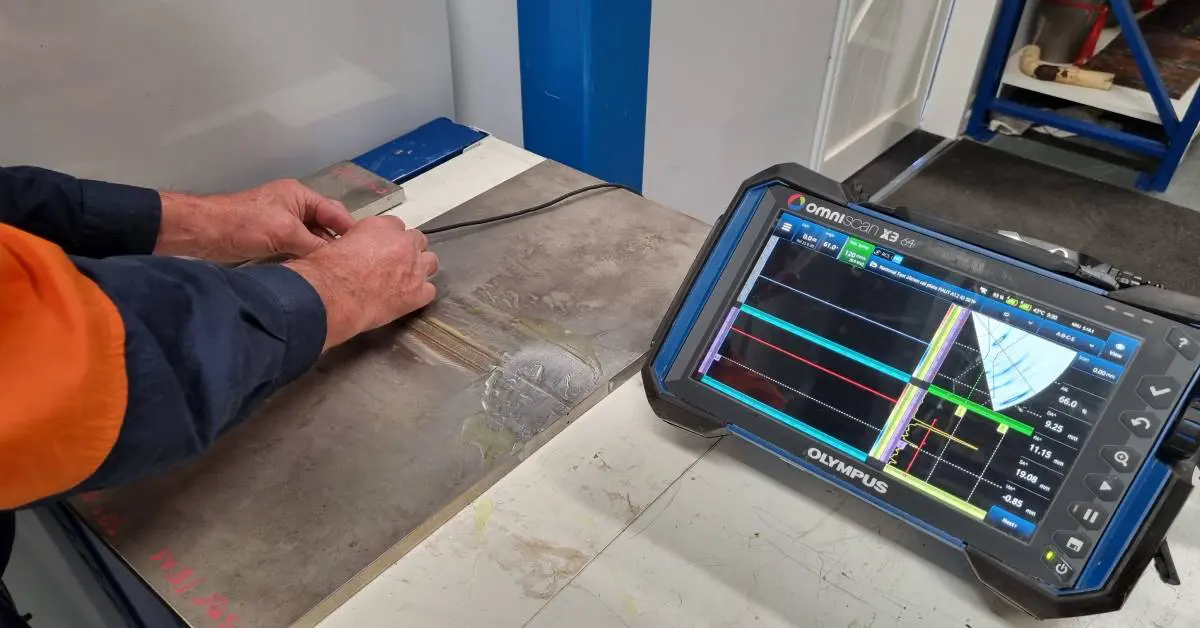 A man is using an electronic device to check the thickness of wood.